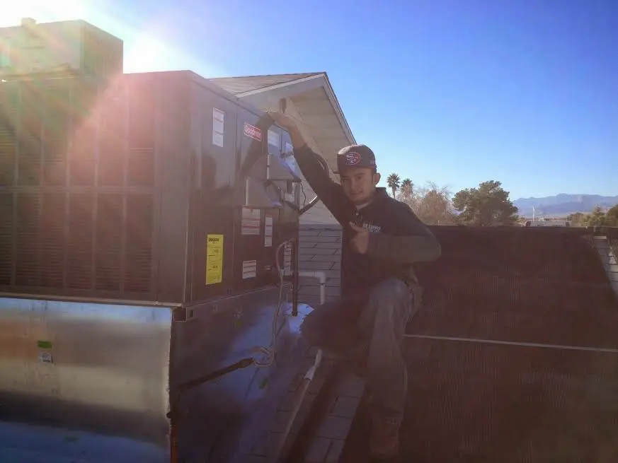 HVAC technician performing Boiler Repair on a rooftop unit in Lyons